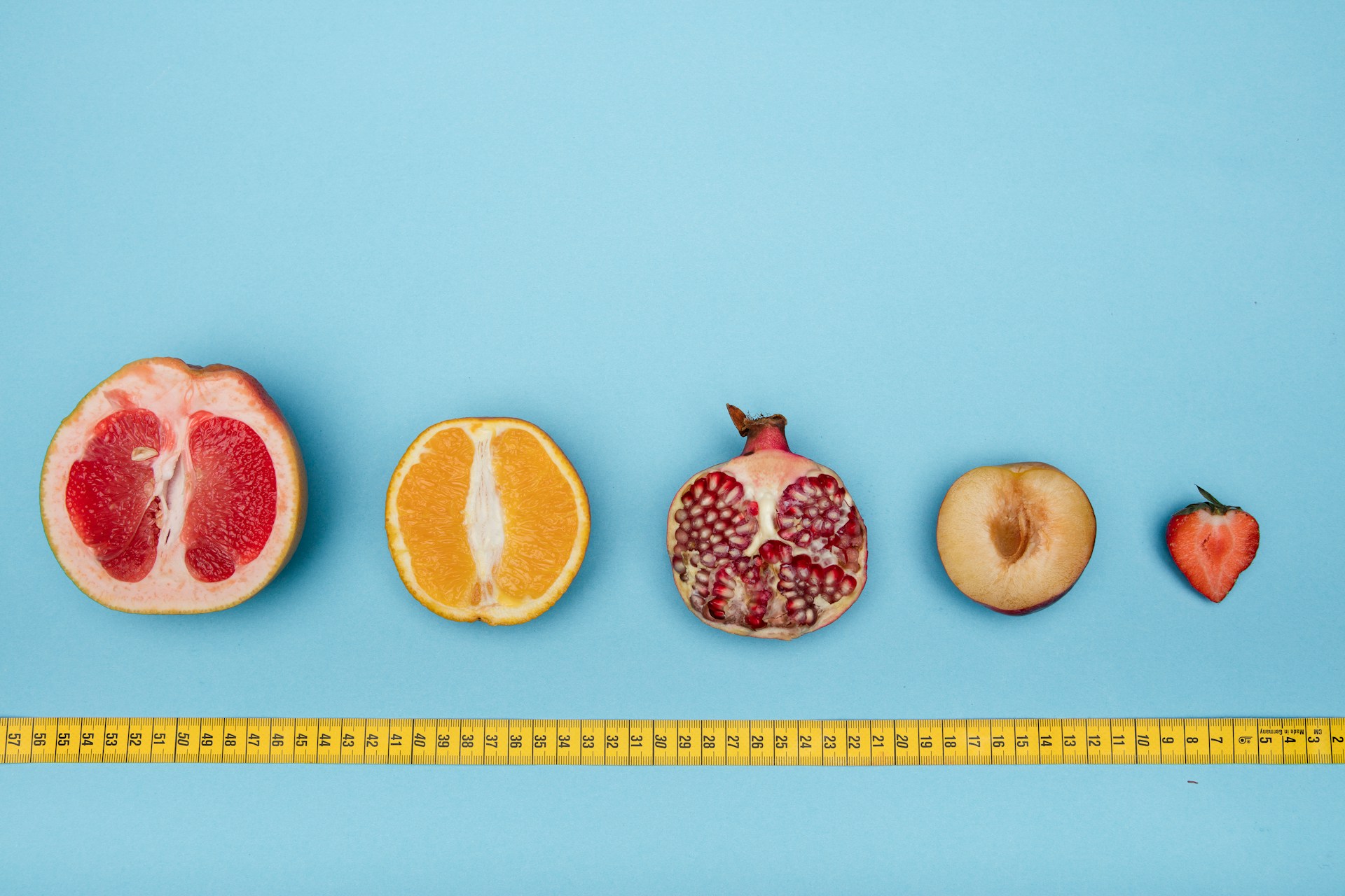 frutas variadas com diferentes tamanhos e uma fita de medir por baixo