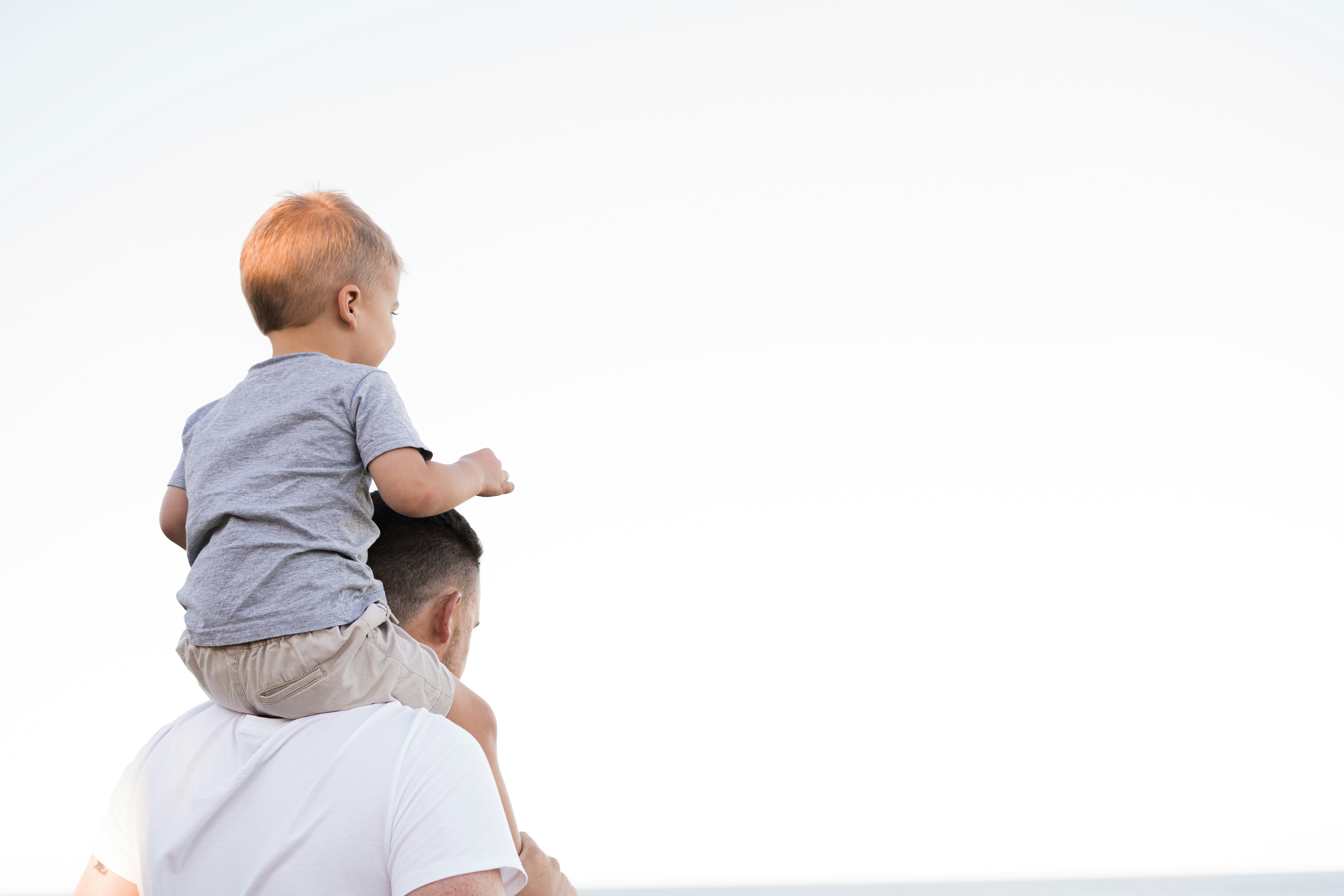 pai a segurar no filho bébé aos ombros