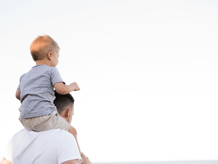pai a segurar no filho bébé aos ombros